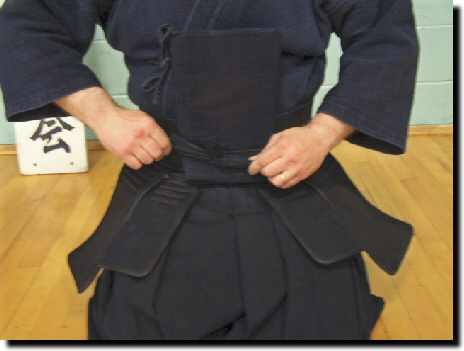 Tie bow under middle tare flap